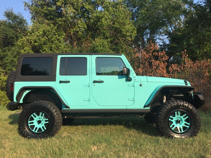 a light blue jeep parked in the grass