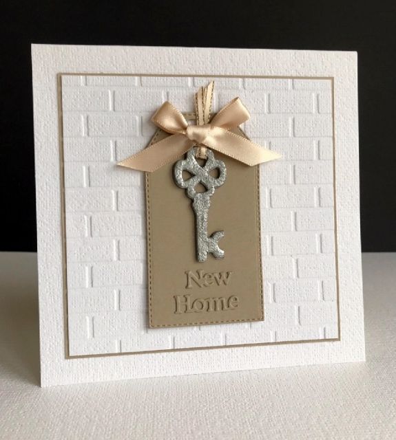 a new home card with a key hanging from it's side and ribbon on the front