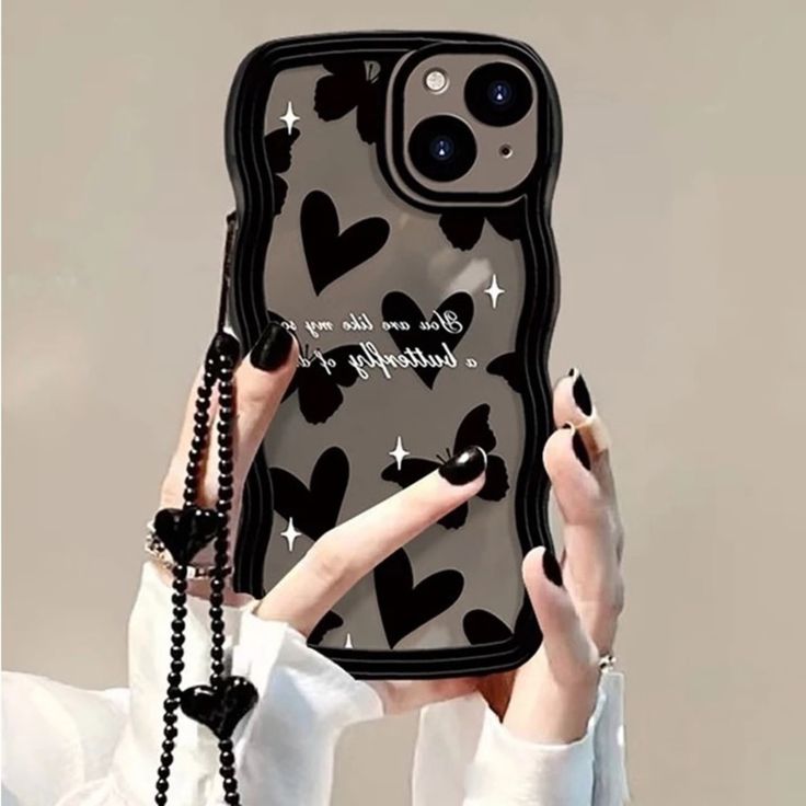 a woman holding up a phone case with hearts on it