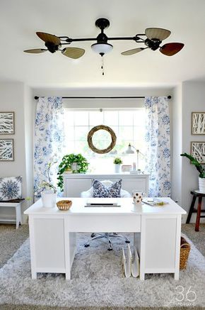 a white desk sitting in front of a window with blue and white decor on it