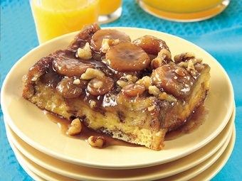 a plate topped with cake covered in nuts next to glasses of orange juice and an orange juice