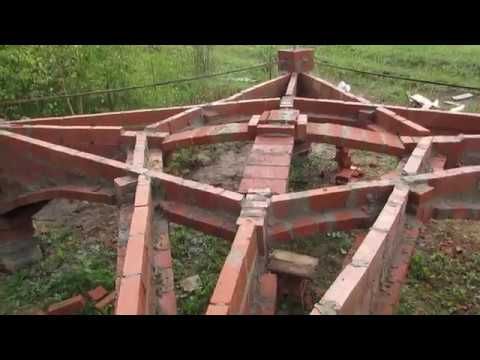 an old wooden boat sitting on top of a lush green field