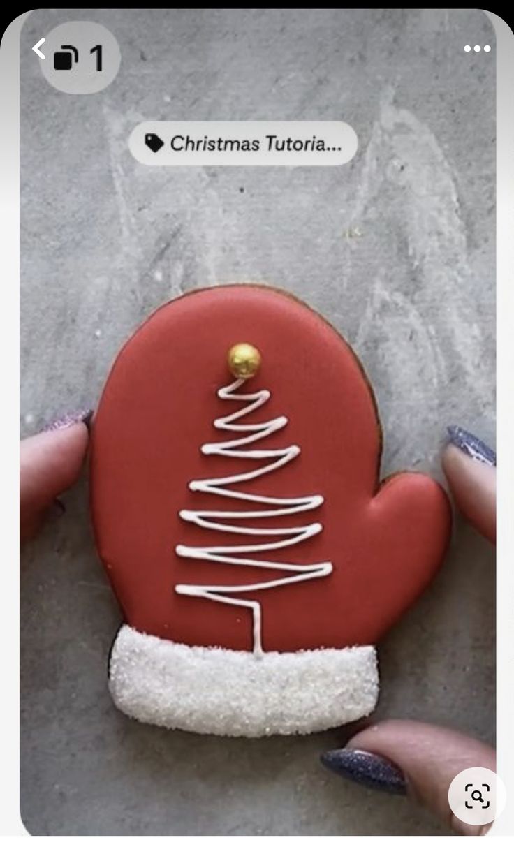 someone is holding a cookie decorated like a christmas tree