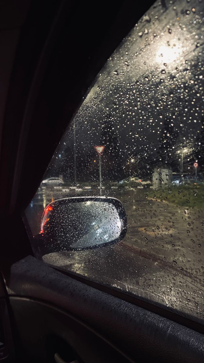 rain is falling on the windshield of a car