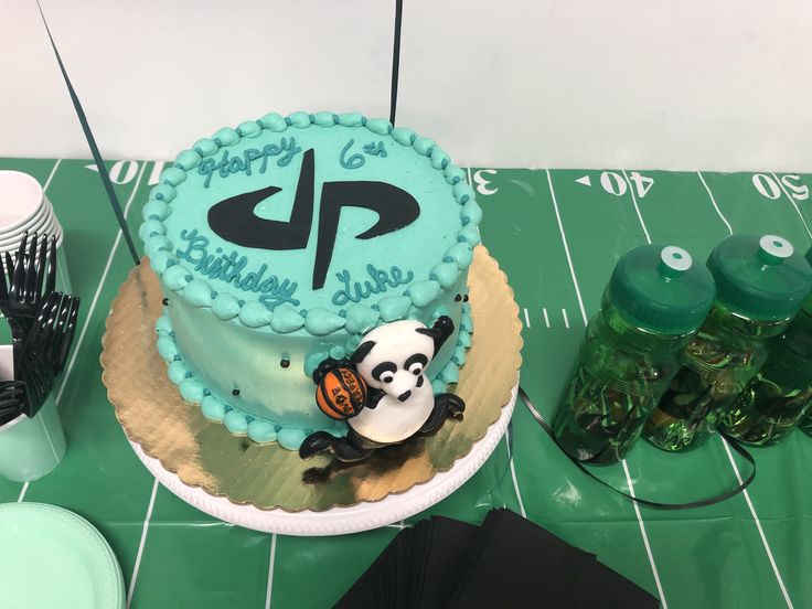 a birthday cake with panda on it sitting on top of a table next to other decorations