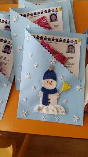 some cards with snowmen on them are sitting on a table and one is holding a cup