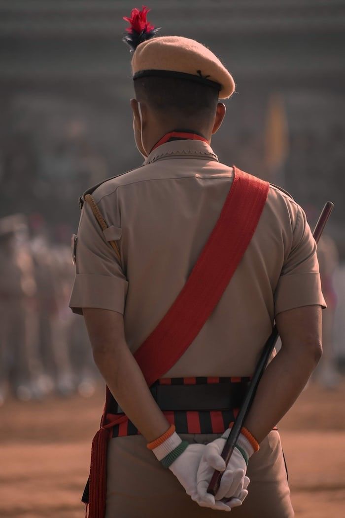 a man in uniform is holding a stick