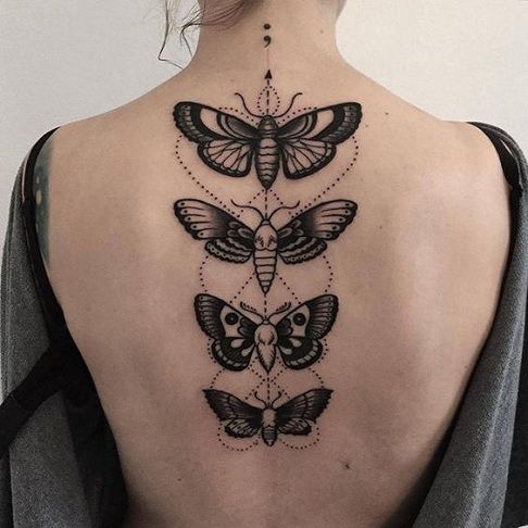 the back of a woman's neck with three butterflies and an owl on it