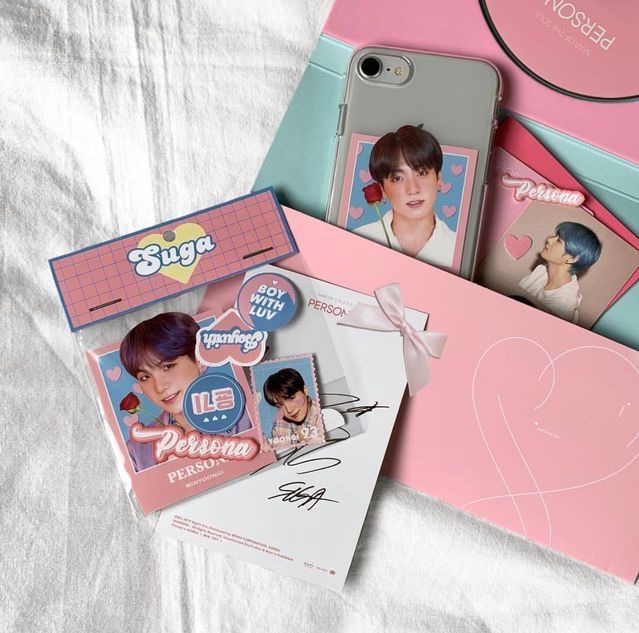 the phone case is pink and has two pictures on it, along with other items