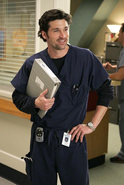 a man in scrubs holding a folder and smiling