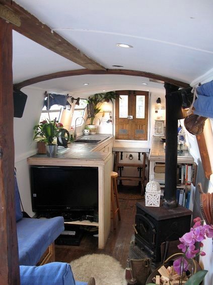 a kitchen and living room are shown in this tiny houseboat style home, which has been converted into a studio apartment with an open floor plan