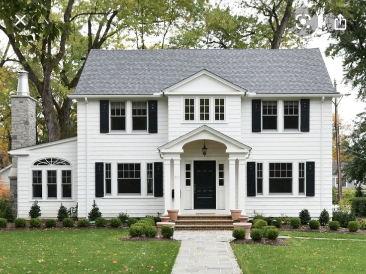 a white house with black shutters and a red sign that says, click here