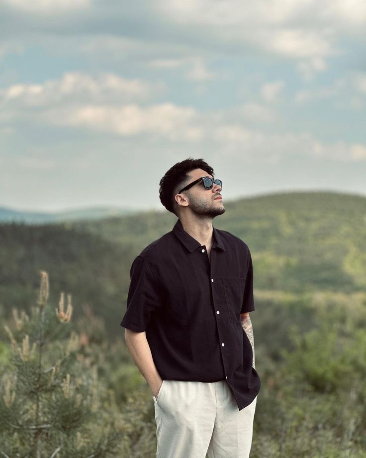 a man standing on top of a lush green hillside