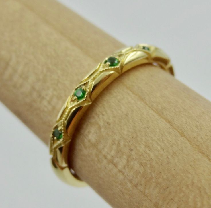 "This beautiful hand engraved and millgrain wedding band is 2.3 mm wide and 1.8 mm tall made of 18k yellow but we can make it in any 18k or 14k color of gold. The 7 tsavorite garnets are set approximately 2/3 way on top and have a total weight of .05 Cts. We can make it any size from 5-7 and you still be able to return it within the listed time frame. Sizing outside of that range can be made as a special order and may require a resize fee if returned. Ring sizing may add additional handling time Gold Art Deco Emerald Ring For Wedding, Anniversary Jewelry With May Birthstone, Gold Emerald Ring Hand Set As A Gift, Tsavorite Birthstone Rings For Wedding, Art Deco Yellow Gold Emerald Ring Stamped 14k, Wedding Jewelry Green Stamped 14k, Wedding 14k Stamped Green Jewelry, Wedding Green Jewelry Stamped 14k, Gold Wedding Jewelry With Certificate Of Authenticity