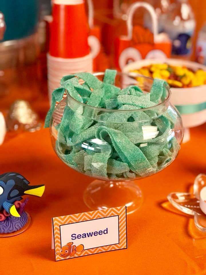 a bowl filled with seaweed on top of a table next to other dishes and decorations