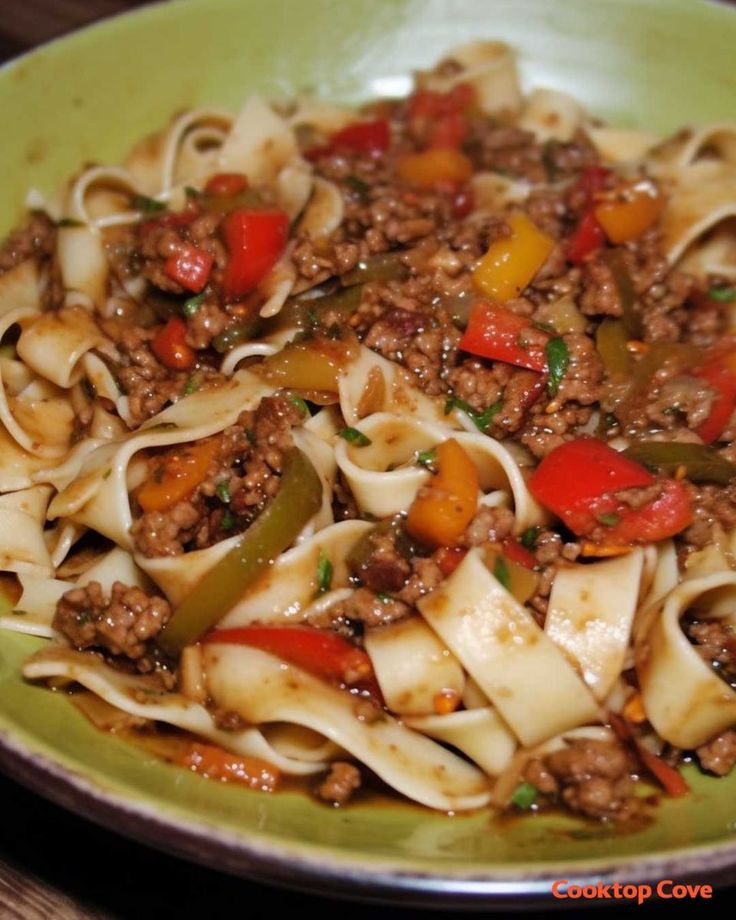 a green plate filled with pasta and meat