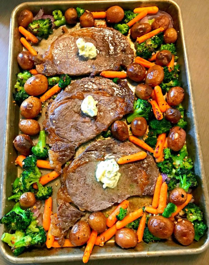 meat and veggies in a roasting pan on a table