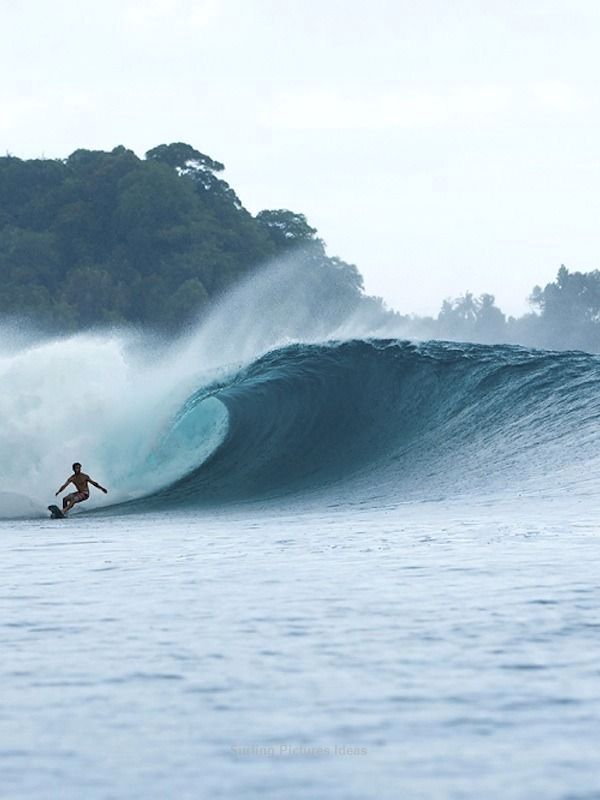 a man riding a wave on top of a surfboard