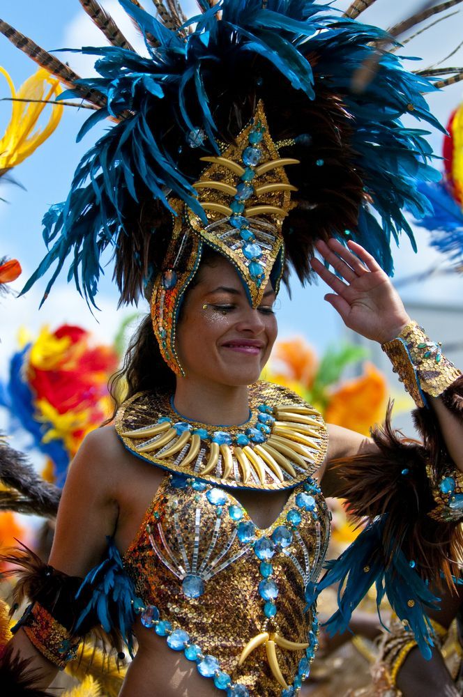 a woman dressed in blue and gold with feathers on her head