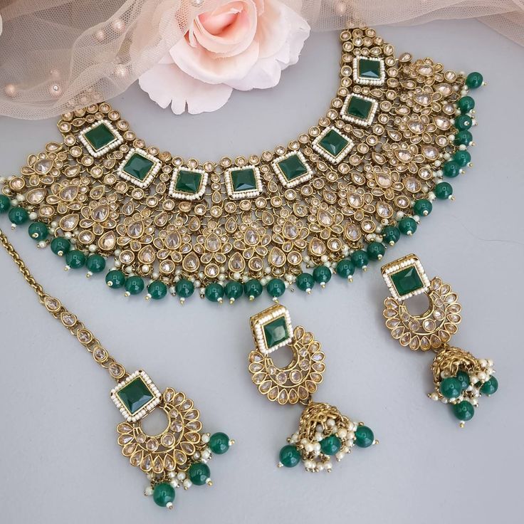 Beautiful Green flexible Antique gold reverse Polki Diamond Choker Necklace set. This choker necklace is a unique blend of bold and classy! Made with fine Diamond Polki on the highest quality brass as the base metal. Necklace width: 6.5cm approx Earrings and tikka drop lenth: 7cm approx width: 4.5cm Delicate necklace accented with oversized emerald color beads. This necklace comes with matching earrings and Maang tikka. Step into the world of high fashion and luxury with this statement piece. Emerald Green Bridal Jewelry Indian, Bridal Choker Necklace, Bridal Jewlery, Green Antique, Diamond Choker Necklace, Bridal Jewellery Design, Bridal Choker, Maang Tikka, Diamond Choker