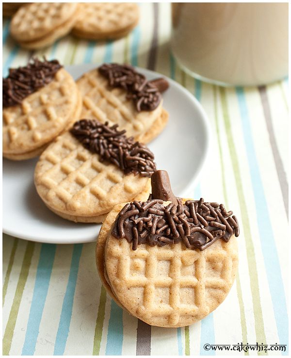 cookies with chocolate frosting and sprinkles are on a plate next to a cup of coffee