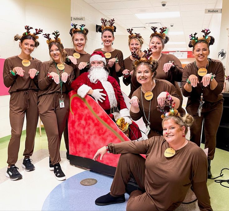 a group of women in brown outfits posing for a photo with santa clause on his sleigh