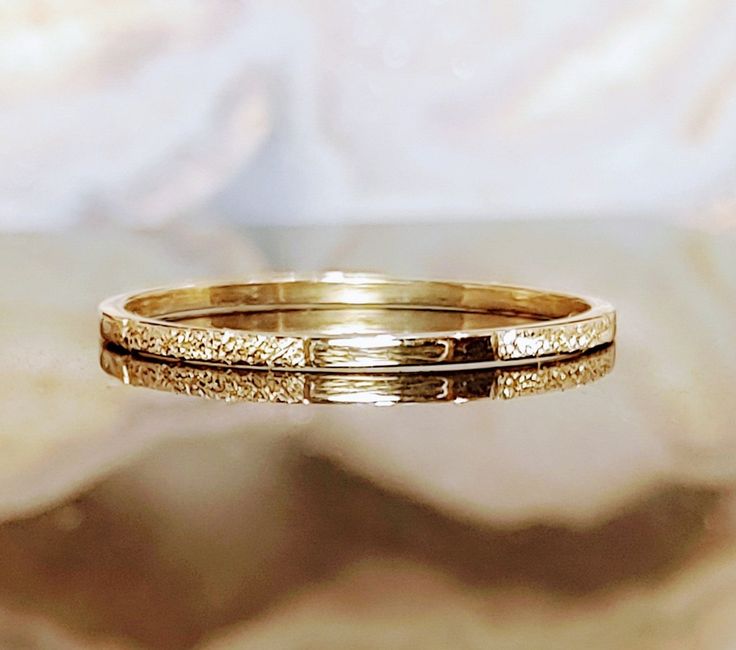 two gold rings sitting on top of each other