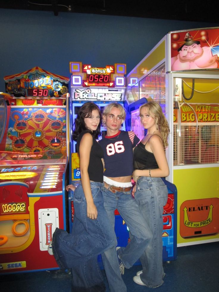 three people standing in front of a game machine