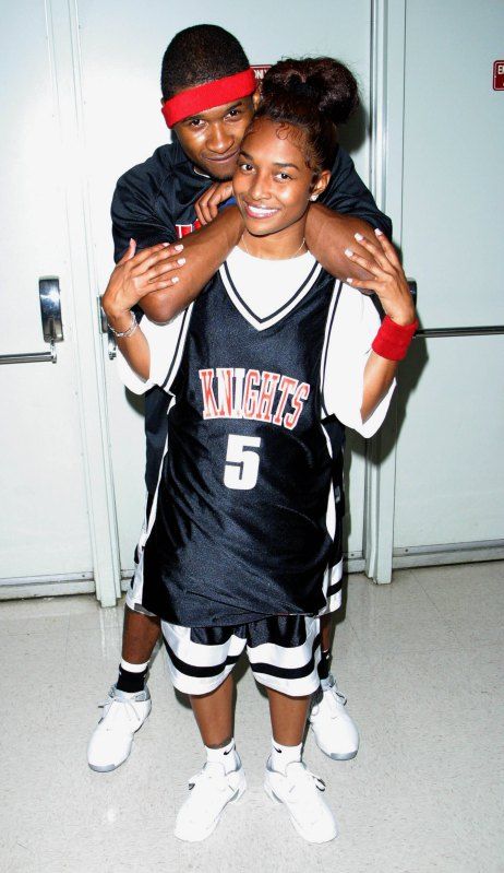 two young people standing next to each other in front of a door with their arms around one another