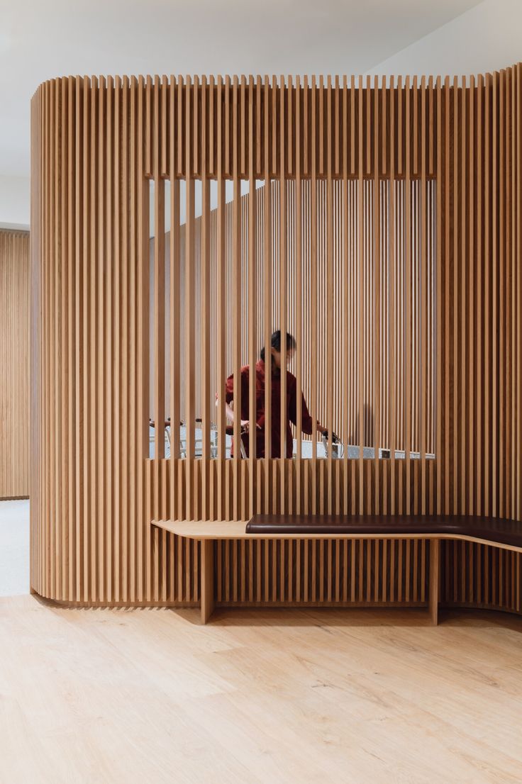 a wooden room divider in front of a mirror with a person looking at it