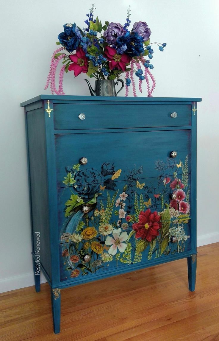 a blue cabinet with flowers painted on it