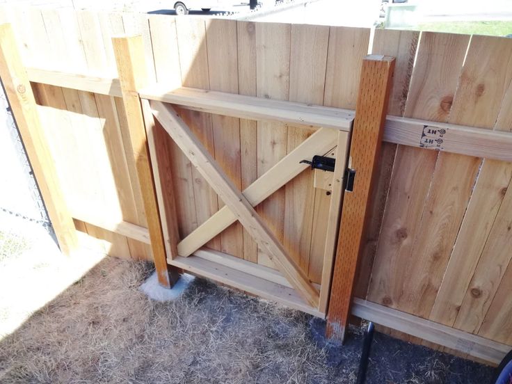 a wooden gate that is next to a fence