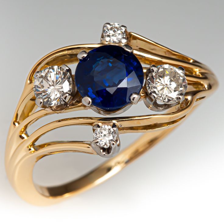 This beautiful ring is centered with a round mixed cut sapphire, weighing 1.00 carats, in a four-prong setting. The top of the ring is four-prong set with four (4) round brilliant cut diamonds. The ring measures 11.2mm at the top, rises 5.4mm above the finger, tapering to 1.5mm wide and 1.0mm thick at the base of the shank. The ring is currently a size 6.25. Engagement Rings Blue, Green Montana, Rings Blue, Sapphire Engagement Rings, Blue Engagement Ring, Round Sapphire, Sapphire Engagement Ring Blue, Sapphire Diamond Ring, Sapphire Engagement