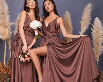 two women in brown dresses posing for the camera