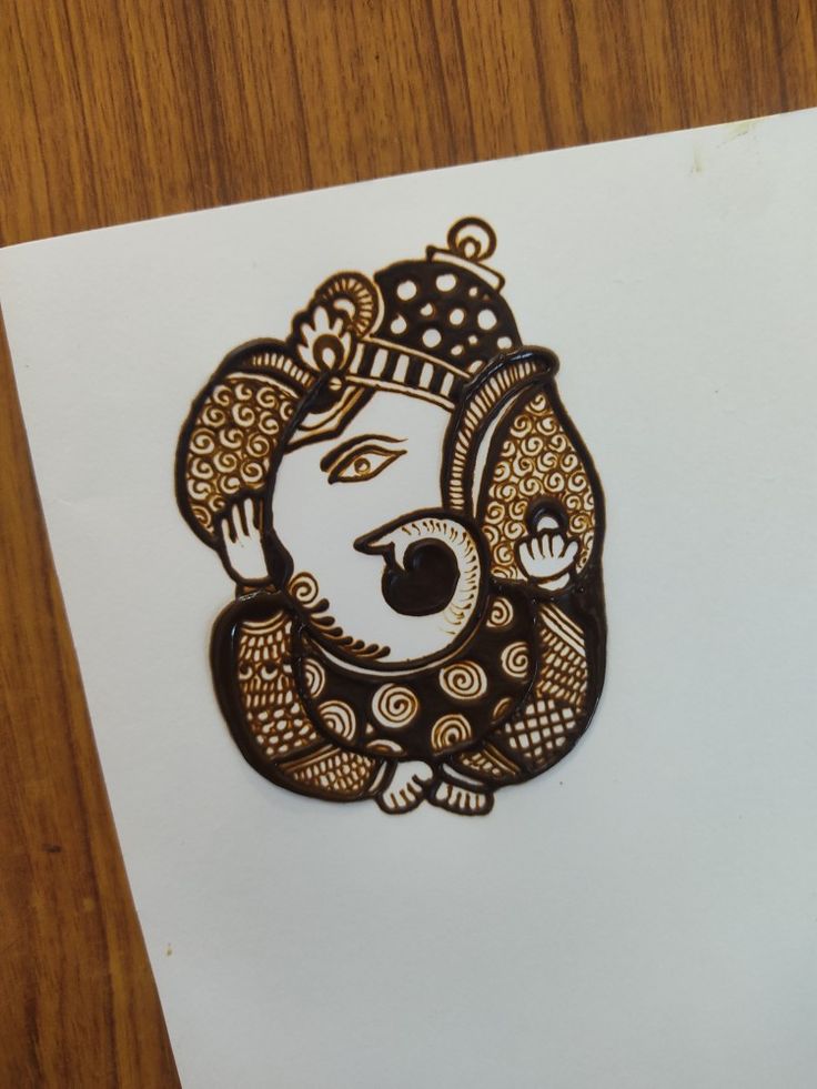 a paper with a drawing of a woman's face in gold and black on it