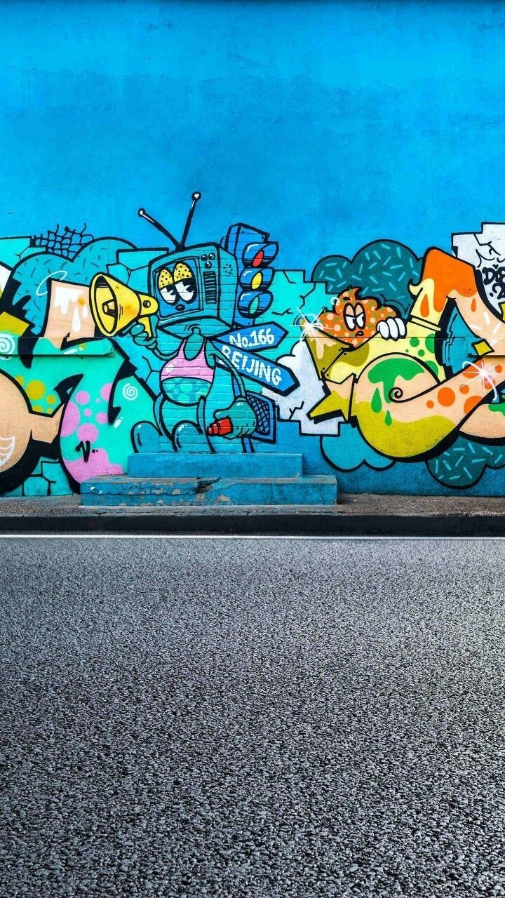 a man riding a skateboard on the side of a wall covered in grafitti