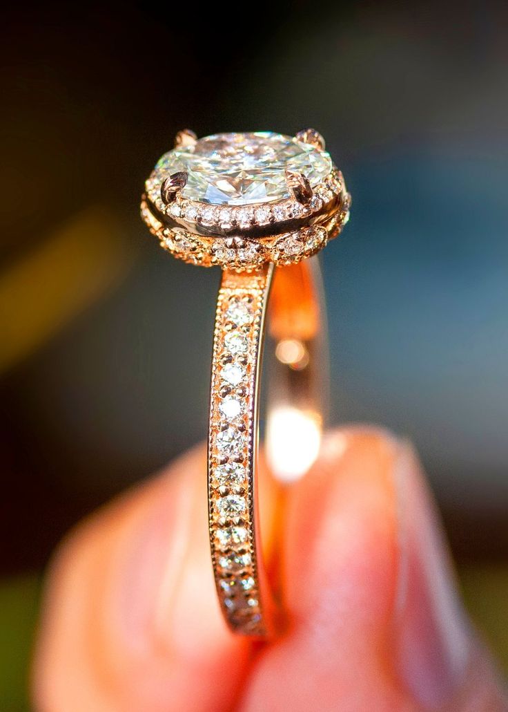 a close up of a person's hand holding an engagement ring