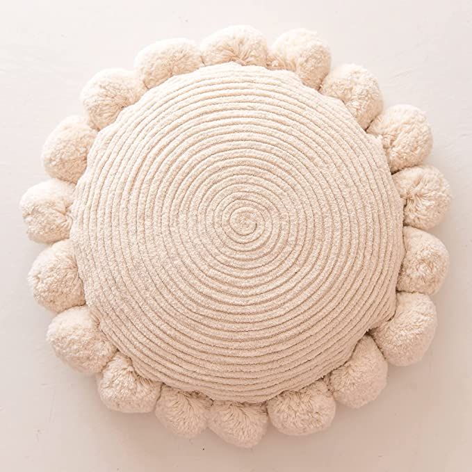 a white circular object with pom - poms on it