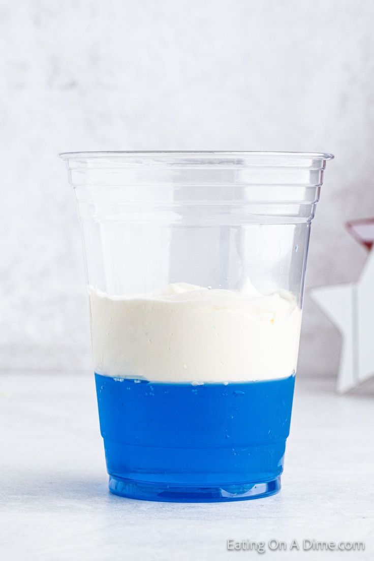 a blue and white cup sitting on top of a counter next to a red star