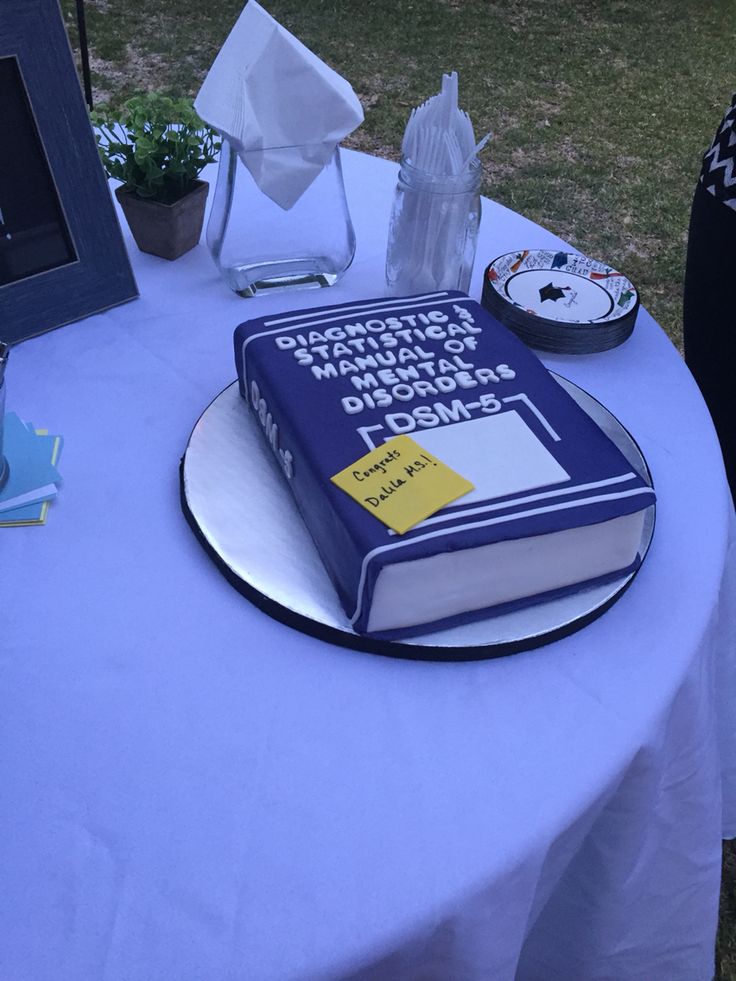 a blue book sitting on top of a table next to a white table cloth covered table