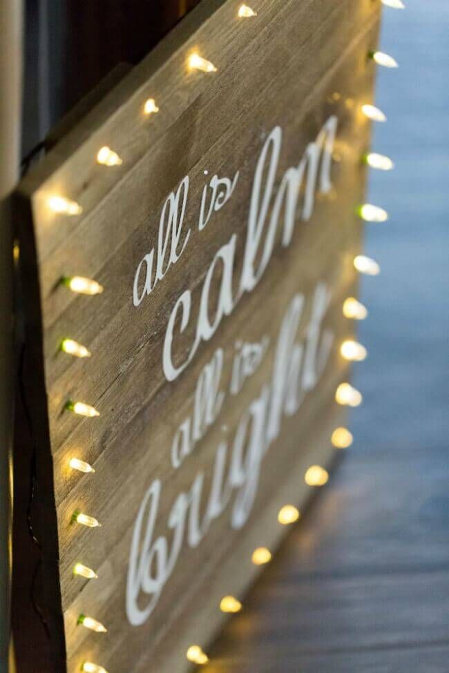 a wooden sign with lights on it that says, all is calm and light up