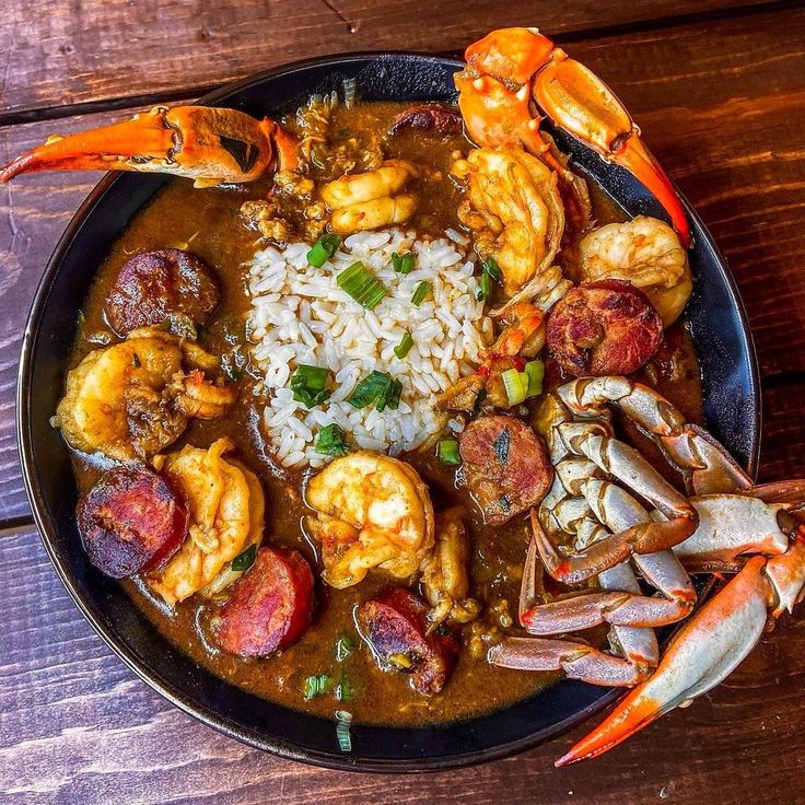 a plate full of seafood and rice on a wooden table