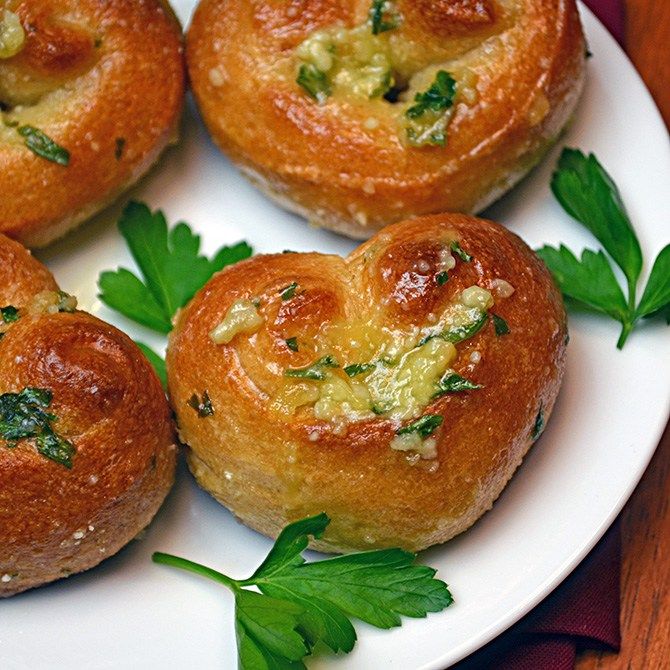 several small rolls on a white plate with parsley