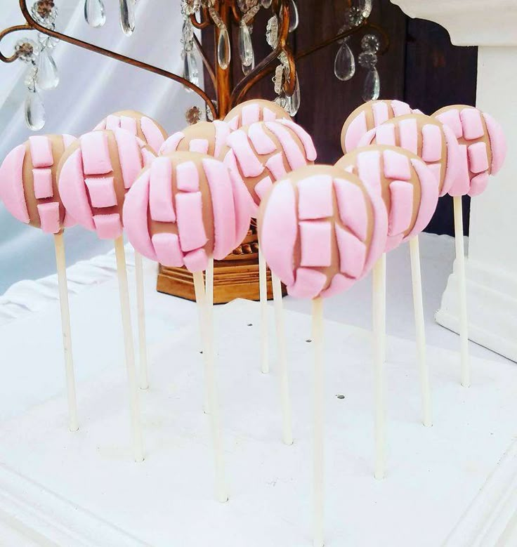 some pink lollipops are sitting on sticks