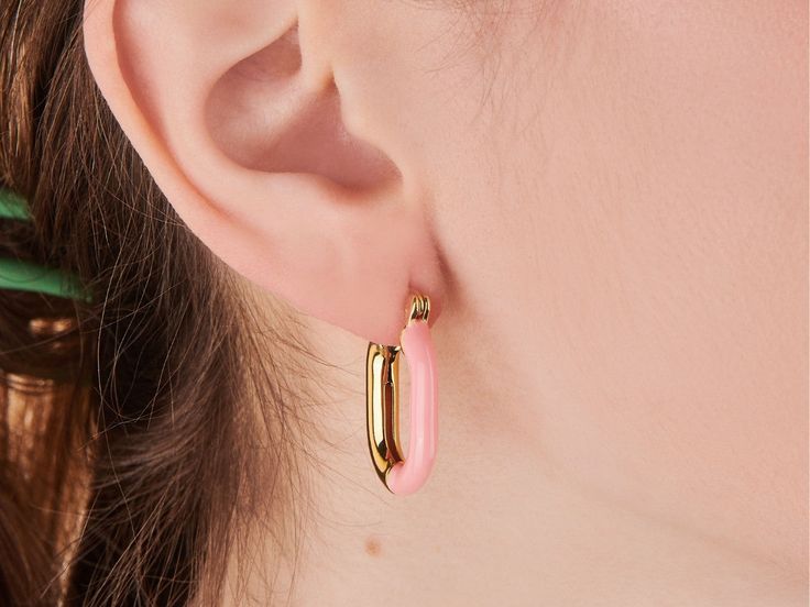 A fun take on the classic hoop. These hoops pair pink enamel and brilliant gold into one must-have design. Wear solo or style with refined studs for a sleek finish. 14k gold plated over brass. Hoop dimension: 18mm x 24mm Hypoallergenic, nickel and lead free Tarnish resistant Everyday Gold Enamel Earrings, Trendy Gold Enamel Hoop Earrings, Trendy Pink Enamel Earrings, Trendy Pink Enamel Jewelry, Pink Enamel Hoop Earrings, Pink Enamel Hoop Jewelry, Minimalist Pink Hoop Earrings For Everyday, Modern Pink Small Hoop Earrings, Modern Pink Small Hoop Jewelry