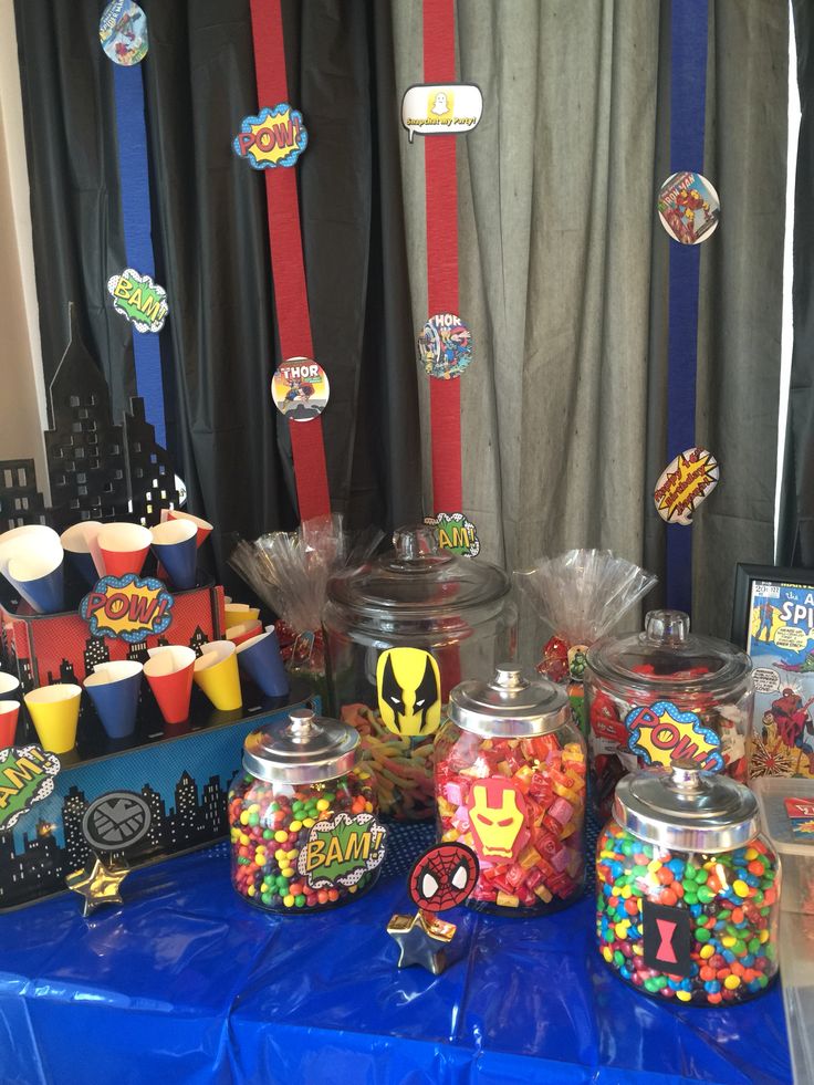 an assortment of candy and candies displayed on a blue table with curtains in the background