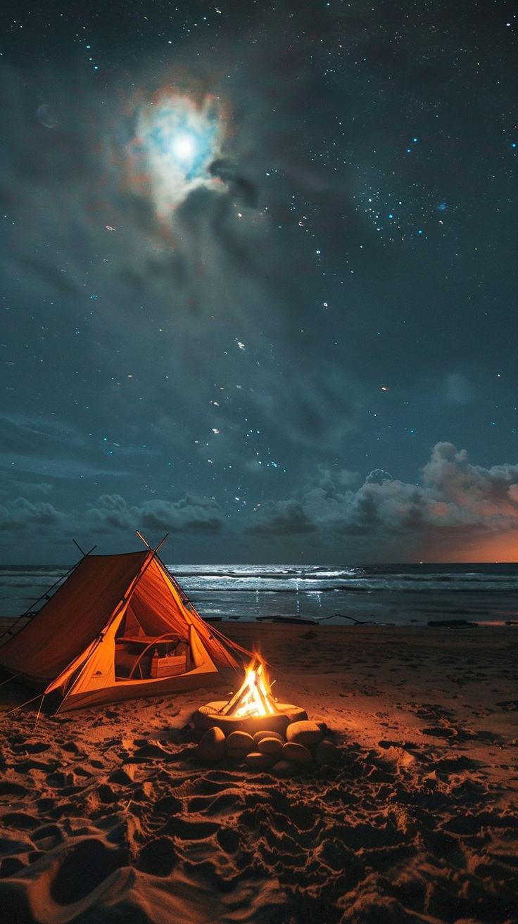 a tent is set up on the beach at night with stars in the sky above