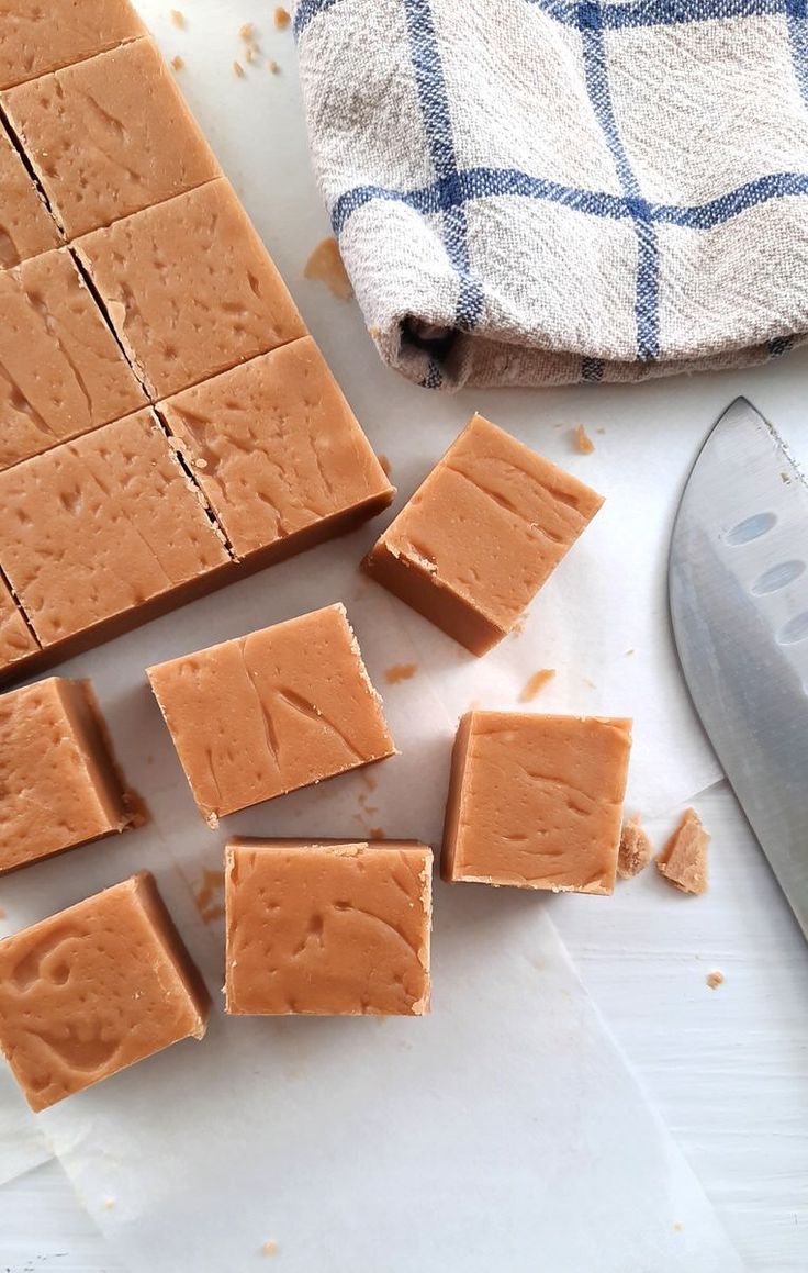 several squares of peanut butter next to a knife