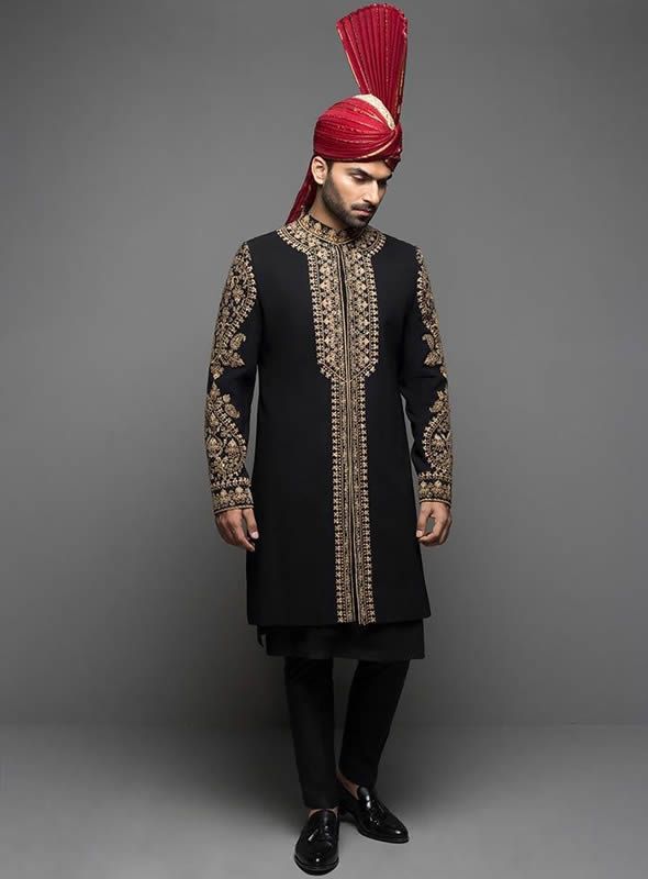 Sherwani:Color: BlackFabric: PC Suiting FabricElegant sherwani features rich quality embellishments accent the collar, sleeves and frontHidden front hooks closure  Inner:Comes with matching kurta and pajama  Additional Accessories: Kolhapuri/Saleem Shahi shoes: US$30 (Made with sherwani material & embroidery) Tied pre-made Turban: US$150 Men's Plain Shawl: US$50  Note: Price of all sherwani suits includes only 3 pieces i.e. sherwani, kurta and shalwar (or whatever bottom is mentioned in product description). Extra charges will apply for any additional accessories like shawl, turban, shoes, jewellery etc.  Made in Pakistan. Traditional Suits With Dabka Work For Festive Occasions, Formal Churidar With Resham Embroidery For Eid, Fitted Embroidered Jamawar Sherwani, Embroidered Fitted Jamawar Sherwani, Traditional Designer Suits With Dupatta, Eid Suits With Dabka Work And Traditional Drape, Gold Long Sleeve Salwar Kameez With Naqshi, Winter Wedding Sherwani With Dabka Work, Fitted Jamawar Sherwani With Intricate Embroidery