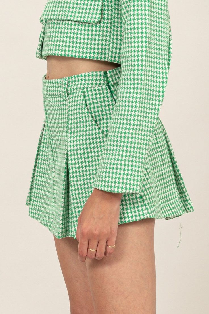 HIGH-WAIST HOUNDSTOOTH PLEATED SKORT Brand: Hyfve Style: HF24E530 Fabric: 100% polyester Details: TURN HEADS WITH THIS FASHIONABLE HOUNDSTOOTH PLEATED MINI SKORT. FEATURING A HIGH-WAISTED DESIGN AND CRISP PLEATS, THIS SKIRT OFFERS A FLATTERING SILHOUETTE. THE VIBRANT GREEN AND WHITE PATTERN ADDS A POP OF COLOR TO YOUR WARDROBE, WHILE THE CONCEALED SIDE ZIPPER ENSURES A SLEEK FINISH. PAIR IT WITH THE MATCHING CROPPED JACKET FOR A COORDINATED LOOK OR MIX AND MATCH WITH YOUR FAVORITE TOPS. PERFECT Plaid Pleated Mini Bottoms, High Waist Plaid Skort For Spring, Spring Plaid High Waist Skort, High Waist Green Skort For Fall, Mini Length Bottoms With Houndstooth Pattern For Spring, Preppy Pleated Skirt Bottoms For Workwear, Preppy Pleated Skirt For Workwear, Preppy Pleated Skirt For Work, Preppy Workwear Pleated Skirt